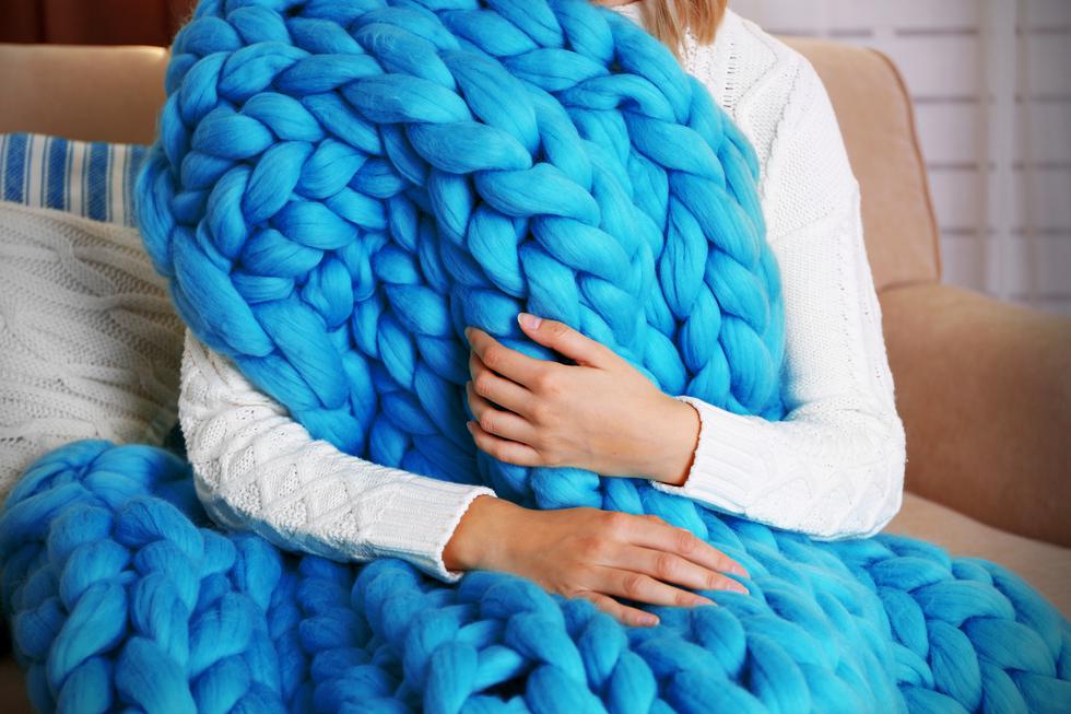 Žena koja rukama, umjesto iglama za pletenje, izrađuje ogromne deke od vune